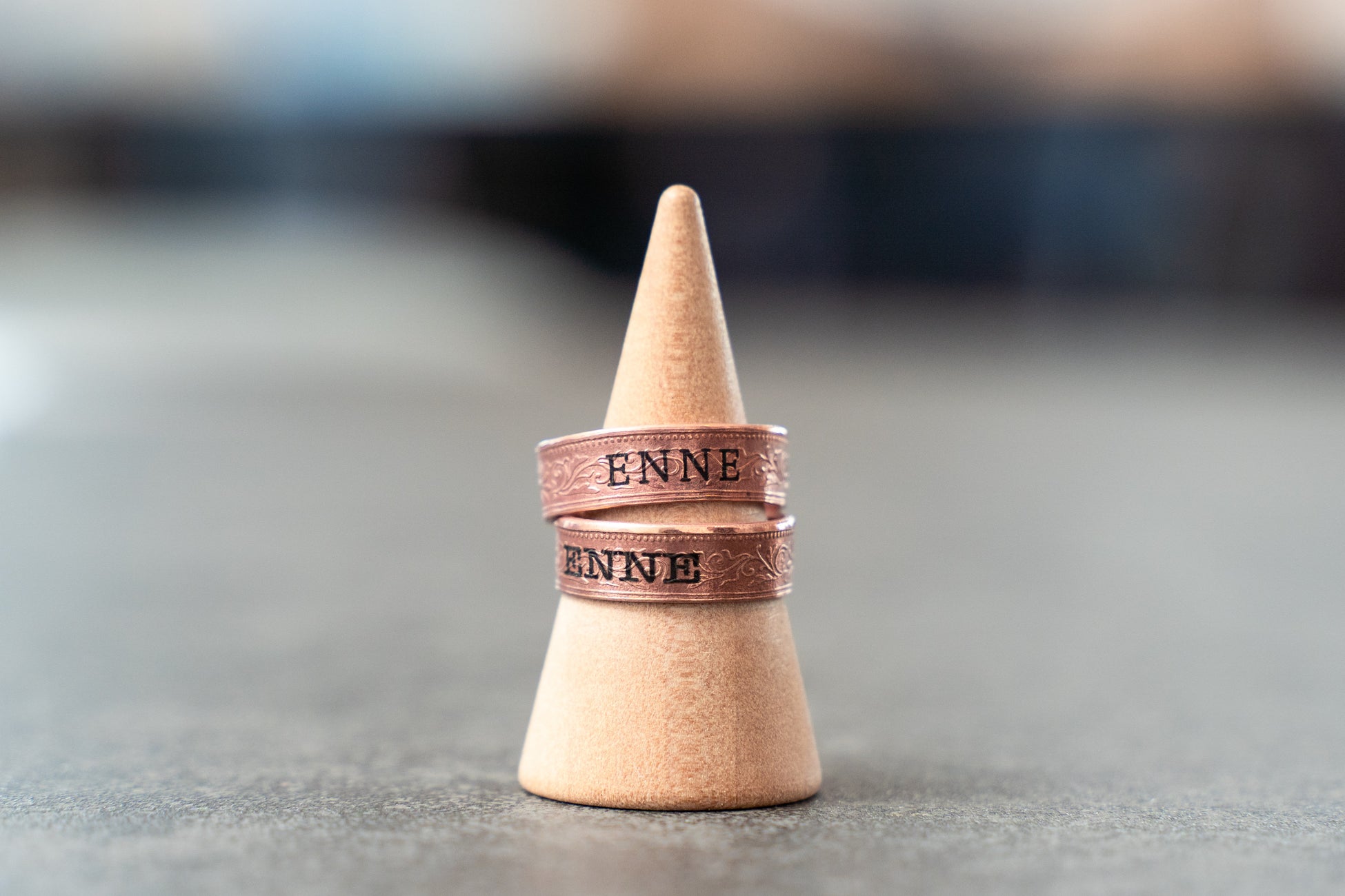 ENNEの文字と模様が入った2本の指輪を、円すい形の台に重ねた公式発表掲載写真。